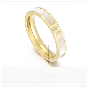 Detailed macro view of gold plated stainless steel ring with white shell inlay and zircons