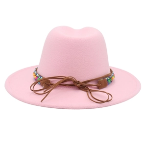 Détail de la texture du chapeau fedora rose avec bande tissée bohème et nœud en cuir brun