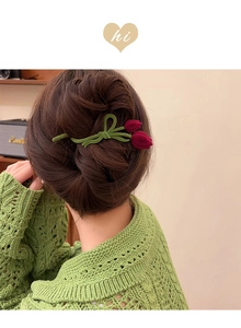 Detail of red flocked tulip hair clip with green leaves on elegant updo hairstyle