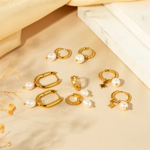 Detail of four pairs of elegant gold pearl earrings with U-shaped and hoop designs