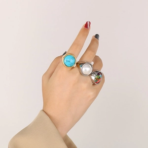Close-up of stacked gold and silver rings set with turquoise, pearl and colorful stones