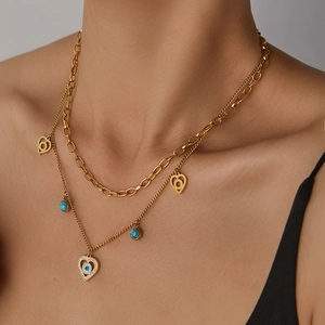 Détail d'un collier doré multicouche avec pendentif œil et perles bleues sur un mannequin