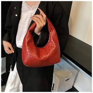 Gros plan sur la texture tressée rouge et forme en croissant du sac à main hobo épuré