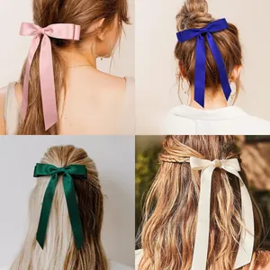 Detail view of elegant satin bow hair clips in pink, blue, green, and beige colors