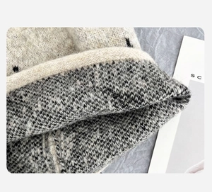 Makroaufnahme der grauen Strickmütze mit Sternenmuster und Rollrand-Textur