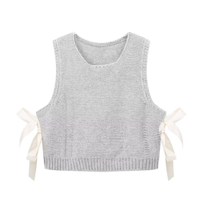 Detail of light grey knit vest featuring white silk bow ties on side slits