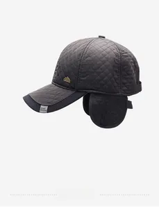 Detailed view of dark grey quilted baseball cap with warm ear flaps and metal logo