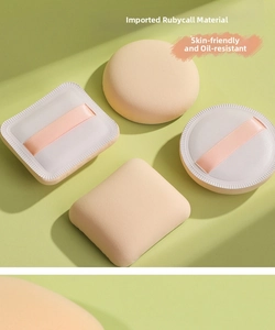 Verschiedene Rubycell-Make-up-Puffs in runden, quadratischen und Rautenformen auf Grün