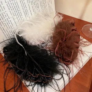Elegant acrylic feather tassel hair clips in white, black and brown on vintage books
