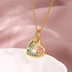 Rainbow crystal heart pendant necklace in gold plating on elegant pink silk background