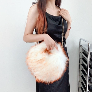 Detail of orange and white faux fur texture on y2k style plush round bag with gold chain