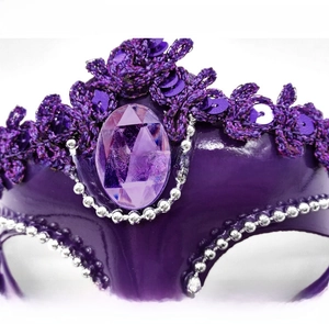 Close-up of purple masquerade mask featuring sequins, faux gems, and silver bead details