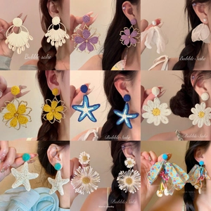 Détails des boucles d'oreilles bohèmes en fleurs tissées et coquillages nacrés