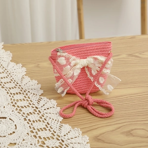 Vue détaillée d'un mini sac en paille tressée rose avec un grand nœud en dentelle délicate