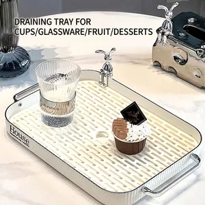 Rectangular cream draining tray with rabbit ornament and metal handles on marble surface