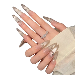 Luxury stiletto press-on nails with pearls, crystals and metallic chains on nude base