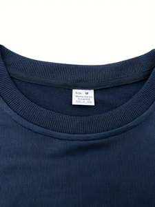 Détail du col rond sur le t-shirt bleu marine avec étiquette de composition et de taille
