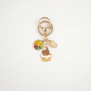 Detail of Capybara keychain featuring rainbow citrus, bear in dessert and pink cupcake charms