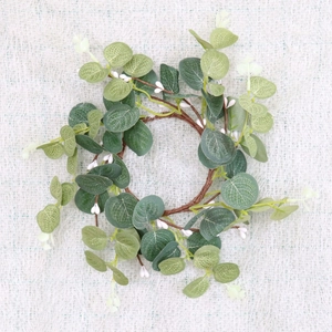 Detail of eucalyptus leaves wreath with white berries on a white textured fabric background