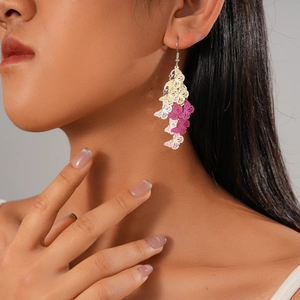 Detail of colorful butterfly drop earring with gradient enamel worn by a female model