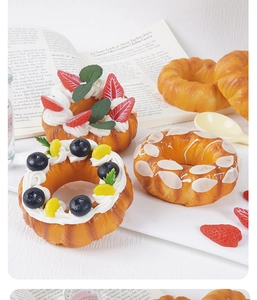 Detaillierte künstliche Donuts mit Erdbeer- und Sahnehäubchen auf einem Holztisch