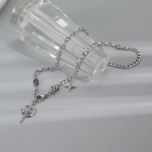 Détail du collier en acier titane avec pendentif étoile-lune et pierre précieuse noire