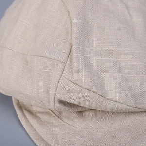 Macro shot of breathable beige linen fabric texture and fine stitching on the stylish cap