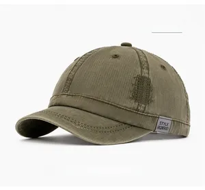 Detailed close-up of distressed cotton canvas and style tag on military green baseball cap