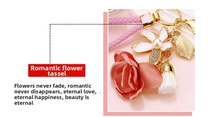 Detail of floral keychain with pink fabric rose, white enamel flower and white tassel