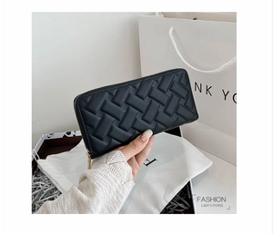 Close-up of black woven PU leather women's long wallet with golden zipper detail