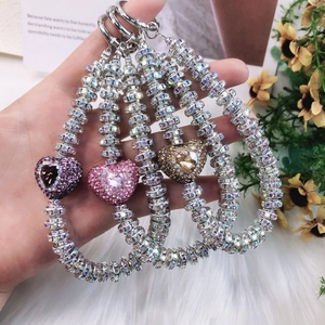 Macro shot of three sparkling rhinestone heart charms in purple, pink and champagne gold colors