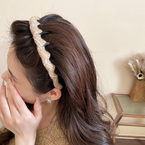 Detail of khaki wavy knit acrylic headband on model showing hair volume and elegant texture