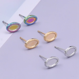 Detailed macro view of oval stainless steel stud earrings in silver gold and rainbow tones