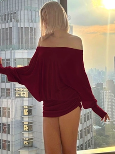 Robe courte bordeaux à col bateau et manches chauve-souris sur fond de ville au coucher