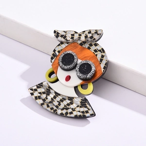 Detailed shot of an acrylic girl brooch with sunglasses and checkered headscarf