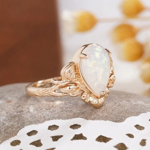 Macro shot of gold leaf-textured ring with a drop-shaped opal stone and intricate details