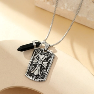 Silver military tag and black crystal pendant necklace on stone display base