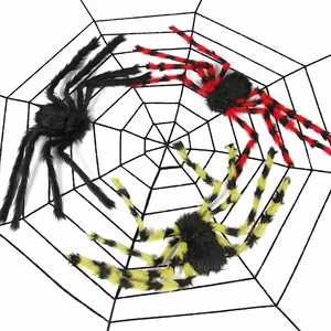 Three plush Halloween spiders in black and striped colors on a large black spider web