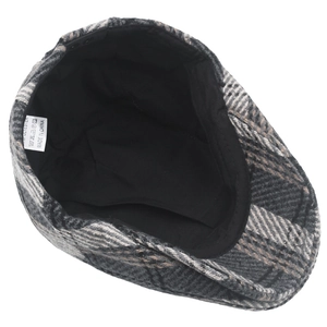 Detail view of the durable polyester lining and care label inside the tweed newsboy cap