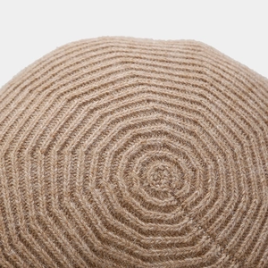 Close-up of wool beret showing intricate spiral knitting patterns and fuzzy texture