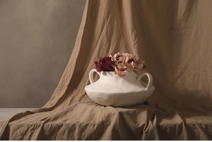 Close-up of white ceramic vase with dual handles and natural hand-kneaded texture