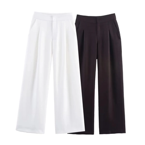 Detail of high waisted wide leg trousers in white and black with pleats and drape texture