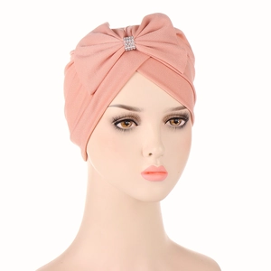 Close-up of pink twisted turban with large bow and glittering silver rhinestone buckle
