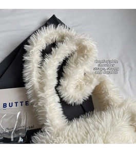 Detail view of the soft white faux fur texture and sturdy shoulder strap of this tote bag