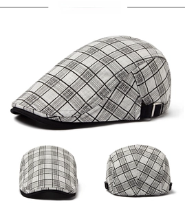 Detail view of plaid newsboy cap with adjustable side buckles and professional display