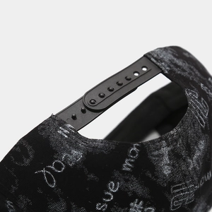 Detail of adjustable snapback closure and graffiti print on a black hip-hop baseball cap