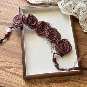 Detailed macro shot of vintage chiffon rose waist chain with colorful wooden beads