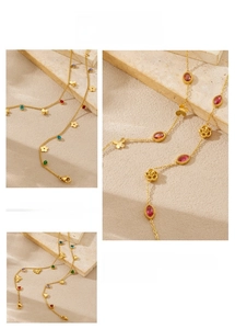 Detail of gold chain bracelets featuring colorful gemstones and floral pendants