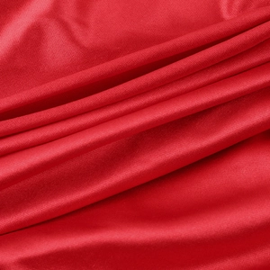 Detailed close-up of high-quality red knitted fabric with soft silky texture and draping