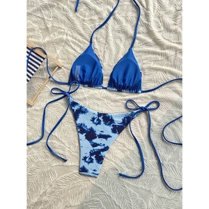 Detail of navy blue tie-dye bikini set with high cut bottoms on beach background
